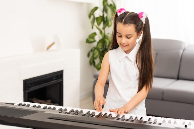 bella ragazza canta mentre suona su un piano elettronico.