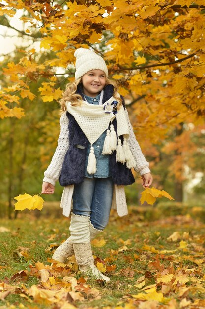 Bella ragazza carina con stivali bianchi in una passeggiata quotidiana nel parco
