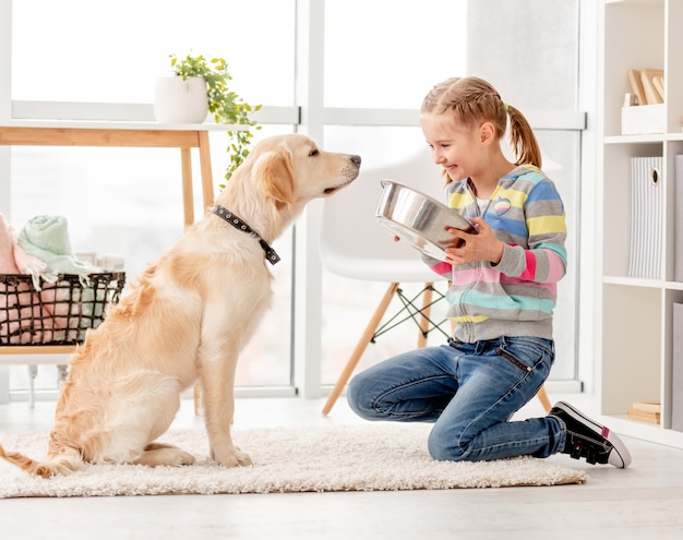 Bella ragazza che alimenta cane sveglio