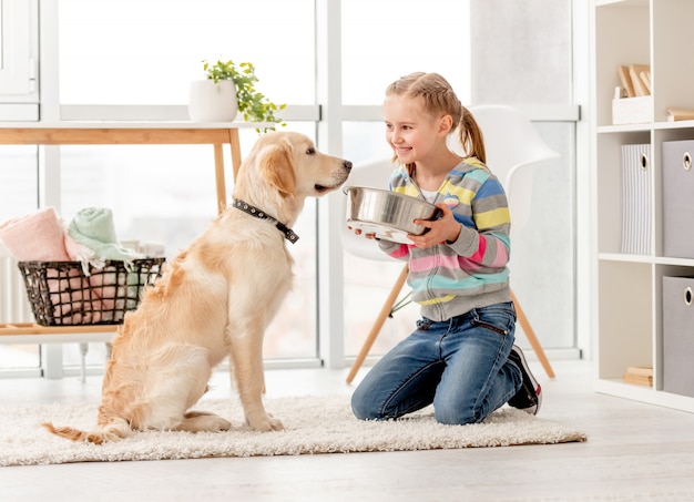 Bella ragazza che alimenta cane sveglio