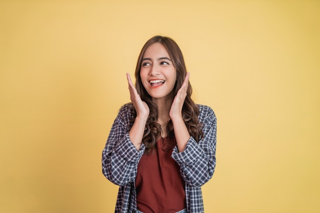 Bella ragazza che alza la mano sul mento quando sorride felicemente