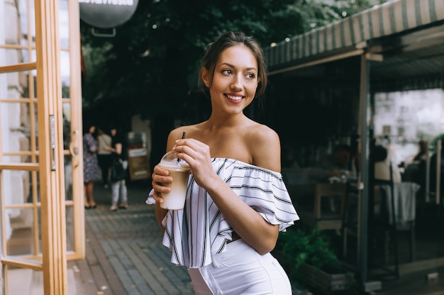 bella ragazza che beve caffè in città