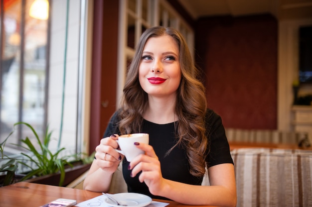 Bella ragazza che beve il caffè