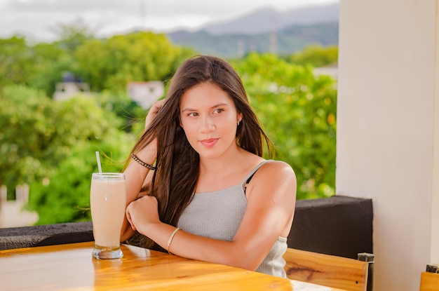 bella ragazza che beve nel tavolo