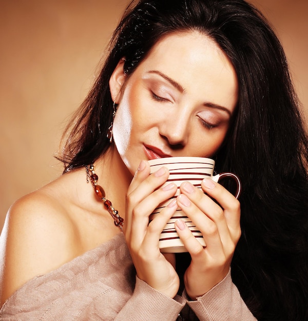 Bella ragazza che beve tè o caffè