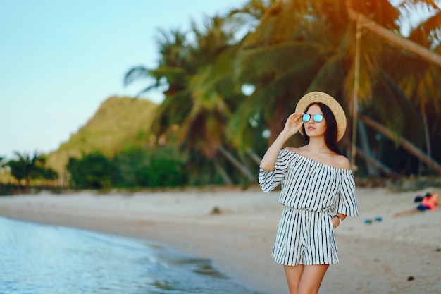 bella ragazza che cammina lungo la spiaggia in Thailandia