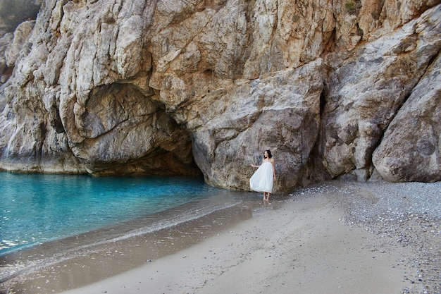 Bella ragazza che cammina lungo la spiaggia