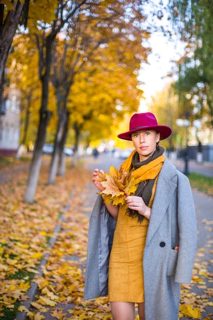 Bella ragazza che cammina nella città autunnale