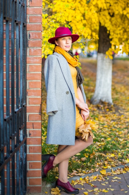 Bella ragazza che cammina nella città autunnale