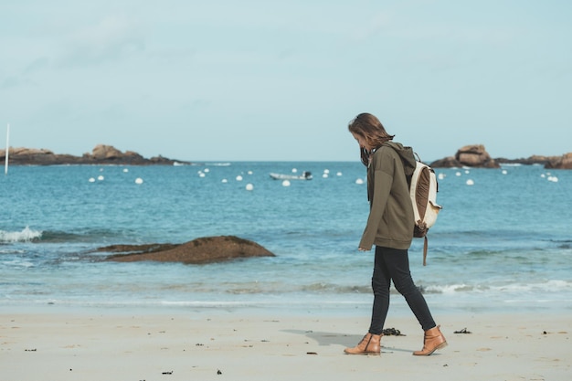 Bella ragazza che cammina sulla riva del mare al Tregastel, in Normandia. Francia