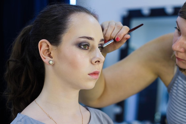 Bella ragazza che fa truccatrice lavoro