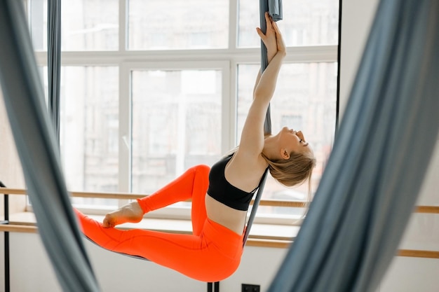 Bella ragazza che fa yoga aereo