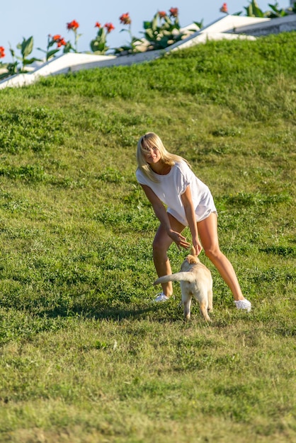 Bella ragazza che gioca con un cucciolo di labrador