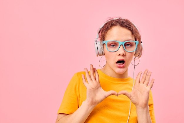 Bella ragazza che indossa occhiali blu che ascolta musica in cuffia vista ritagliata inalterata