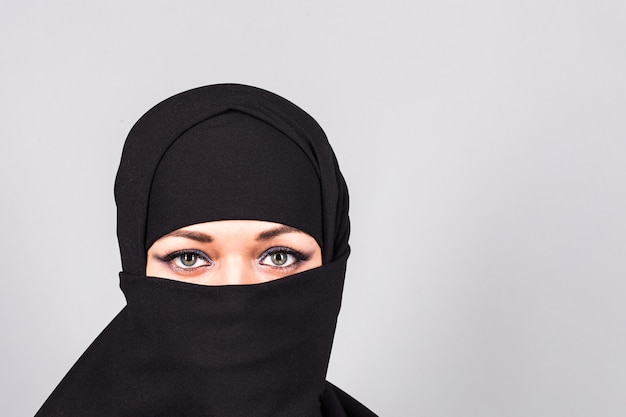 Bella ragazza che indossa un niqab - sfondo grigio