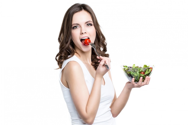 Bella ragazza che mangia cibo sano. Isolato.