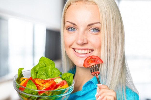 Bella ragazza che mangia un'insalata