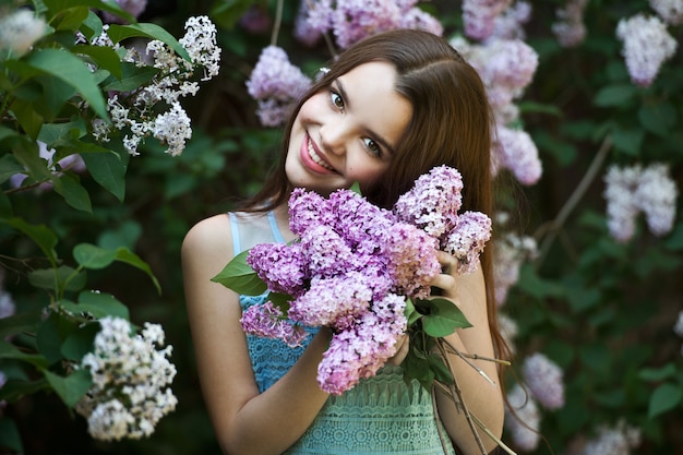 Bella ragazza che posa in un giardino lilla