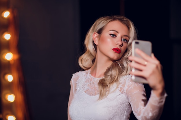 Bella ragazza che prende selfie in specchio