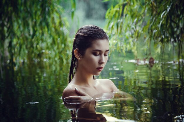 Bella ragazza che riposa in acqua. La donna alla cieca, galleggia lungo il fiume, meditando nell'acqua