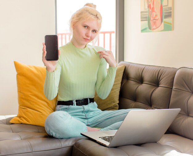 Bella ragazza che sembra arrogante, di successo, positiva e orgogliosa, che indica se stessa