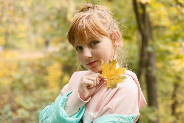 Bella ragazza che si diverte nel parco autunnale