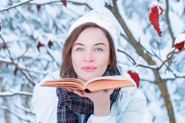 Bella ragazza che soffia sulle pagine del libro