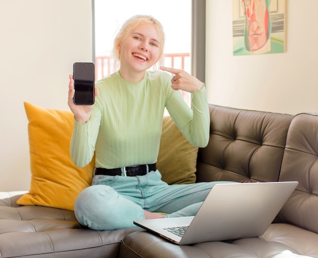 Bella ragazza che sorride con sicurezza indicando il proprio ampio sorriso, atteggiamento positivo, rilassato e soddisfatto