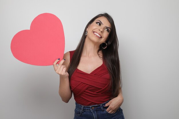 Bella ragazza che tiene il regalo di San Valentino su sfondo bianco