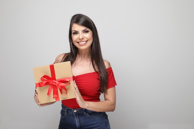 Bella ragazza che tiene il regalo di San Valentino su sfondo bianco