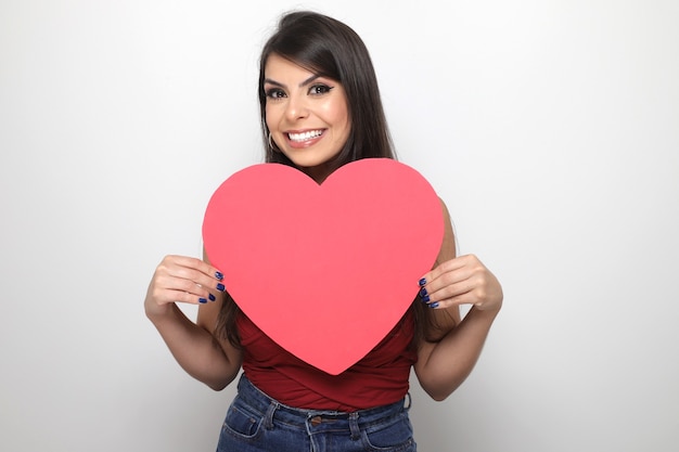 Bella ragazza che tiene il regalo di San Valentino su sfondo bianco