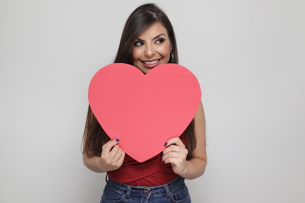 Bella ragazza che tiene il regalo di San Valentino su sfondo bianco