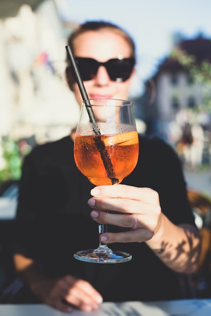 Bella ragazza che tiene un bicchiere con un cocktail