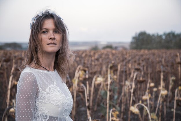 Bella ragazza con abito bianco in campo senza trucco immagine semplice e chiara