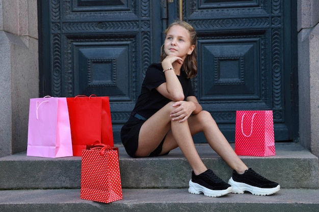 Bella ragazza con borse colorate in città