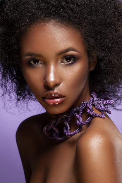 Bella ragazza con capelli mossi, trucco professionale, fotografata in studio.