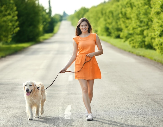 Bella ragazza con cute retriever sulla strada