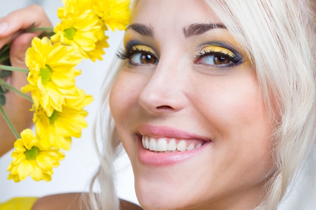 Bella ragazza con fiori gialli