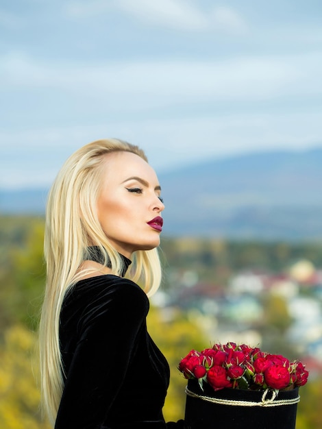 Bella ragazza con fiori in scatola