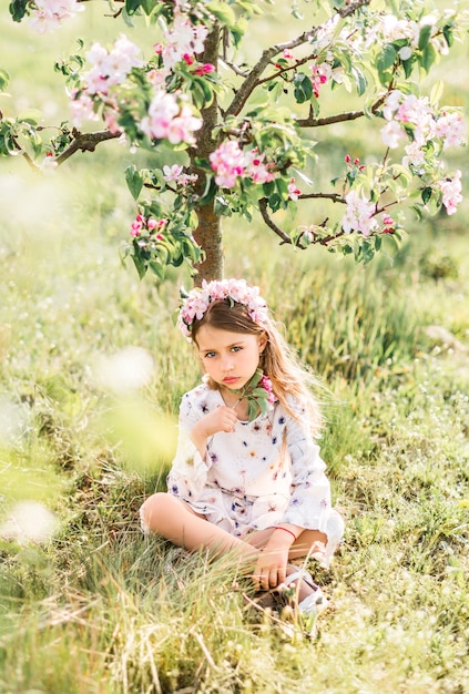 Bella ragazza con ghirlanda floreale in natura