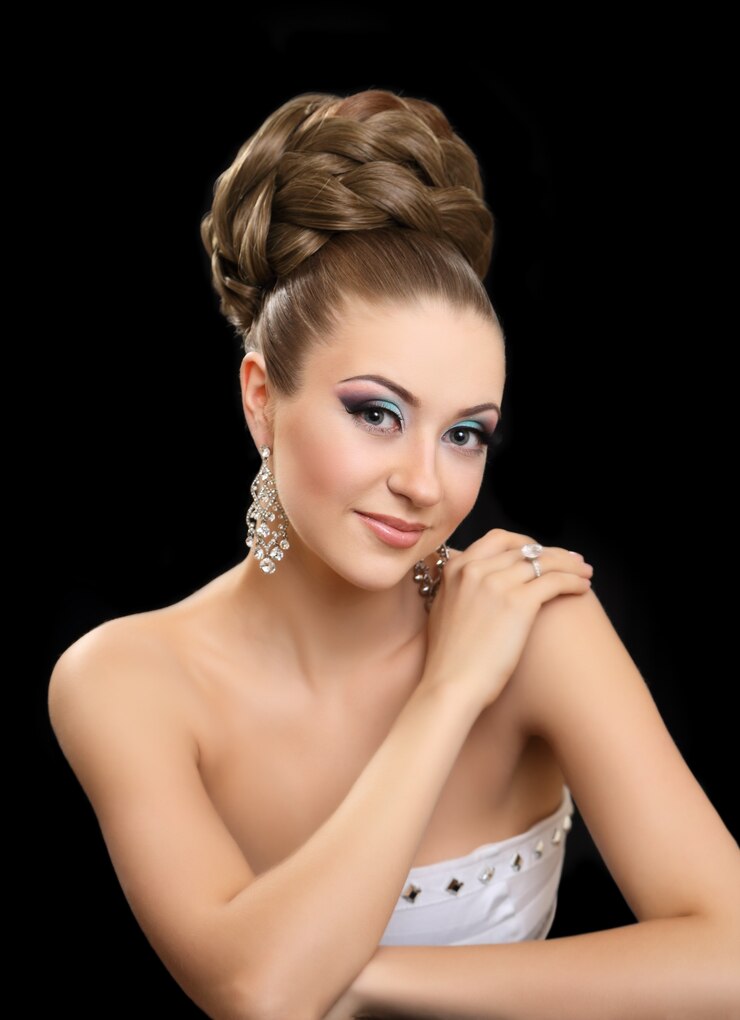 Bella ragazza con i capelli alti e il trucco luminoso.