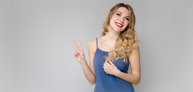 Bella ragazza con i capelli forti mostra due dita.