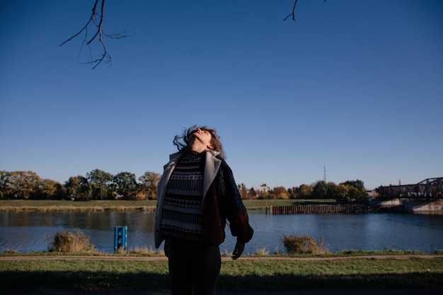 Bella ragazza con i capelli lunghi che ballano contro il cielo blu.