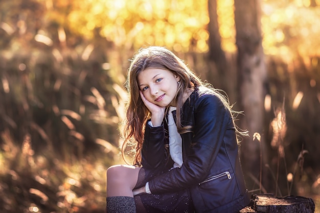 bella ragazza con i capelli lunghi, seduta sulla natura