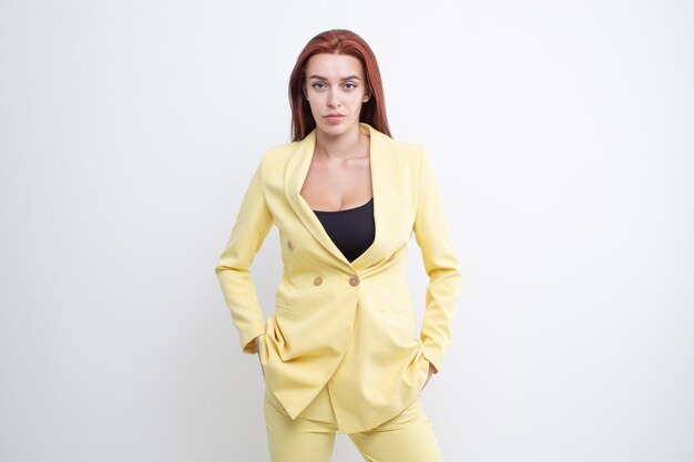 Bella ragazza con i capelli rossi in posa in tailleur giallo