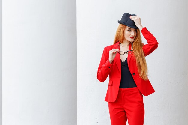 Bella ragazza con i capelli rossi vestita con un tailleur rosso Ritratto di affari