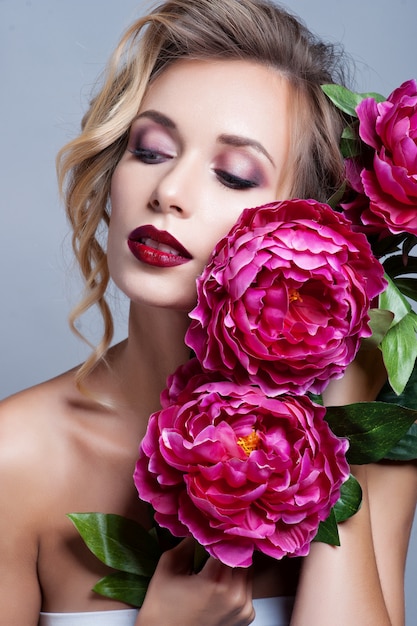 Bella ragazza con i fiori di primavera. Pelle fresca