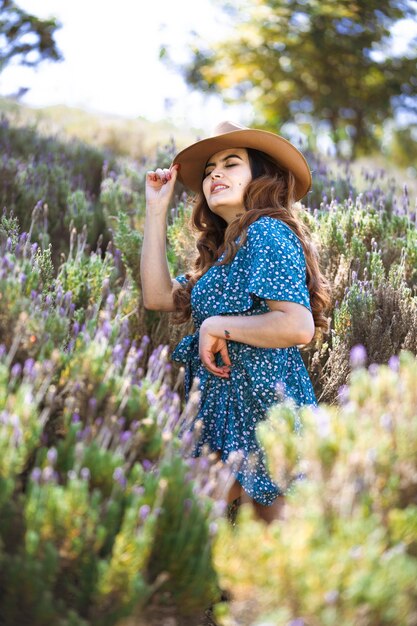 Bella ragazza con i fiori sopra lo studio ciano