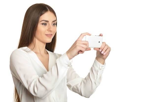 Bella ragazza con il cellulare su sfondo bianco