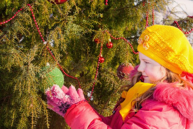 Bella ragazza con l'albero di Natale a winter park